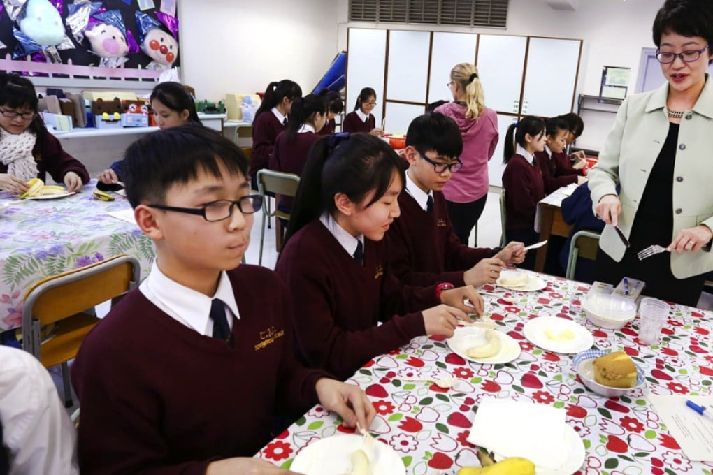 Bernice Lee, founder of the Etiquette and Leadership Institute, shows students how to use a knife and fork. Photo: Jonathan Wong