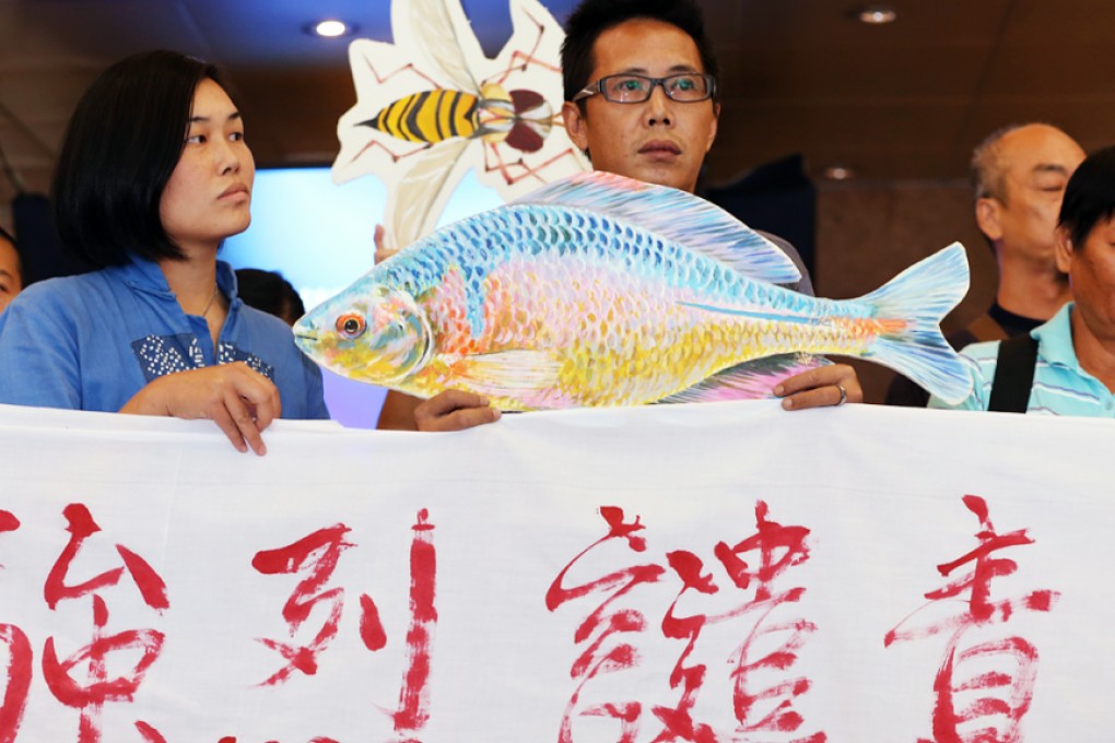 Au Hei-man (left), member of the League of Fanling North Villages and Residents; and Lee Siu-wah (centre), chairman of Kwu Tung North Development Concern Group, together with villagers petition to the Town Planning Board to veto the North East New Territories development plans at Town Planning Board in North Point Government Offices in October, 2014. Photo: Nora Tam