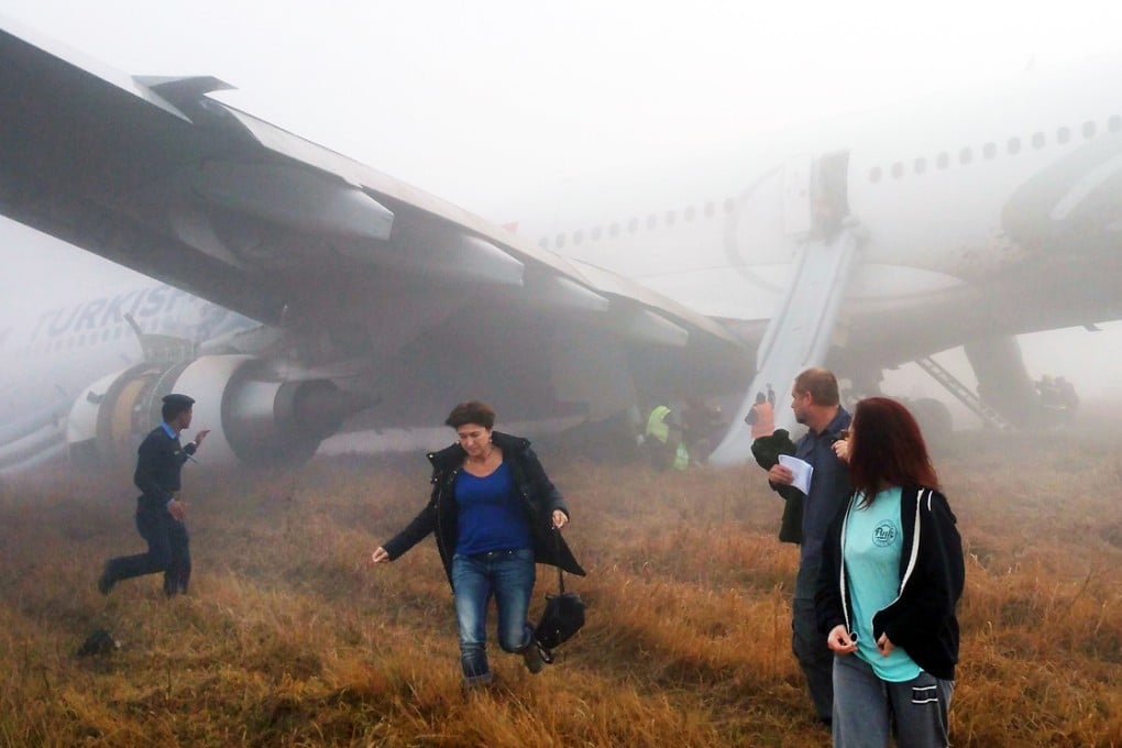 Relieved passengers emerge from the plane after the plane screeched to a halt following a terrifying landing. Photo: AFP