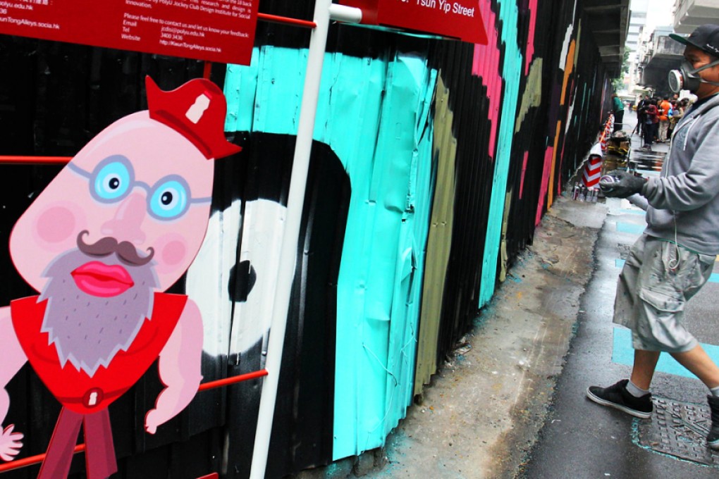 Local artist 4Get paints a graffiti mural on a disused bus depot in Kwun Tong as part of the alley-painting project. Photo: Dickson Lee