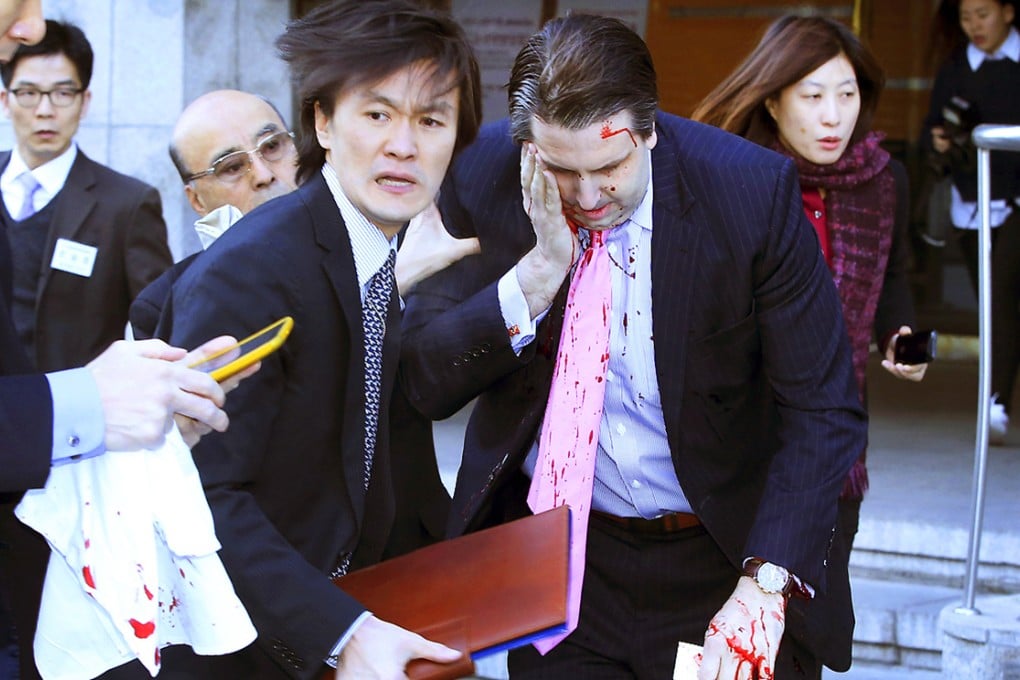 Mark Lippert is helped away from the scene of the attack in downtown Seoul. Photo: AP