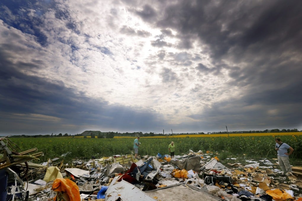 Journalists look at debris from the Boeing 777 Malaysia Arilines flight MH17. Photo: EPA