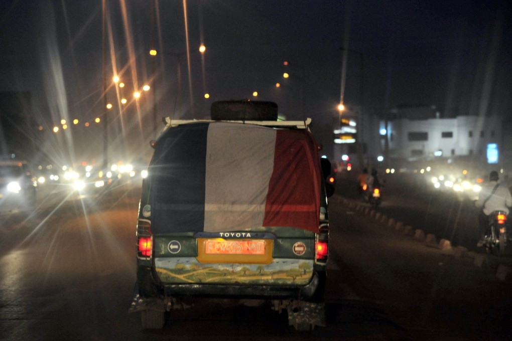 A van draped with a French flag travels in Bamako, Mali, the site of a deadly shooting attack that left two Europeans and two locals dead. Photo: AFP