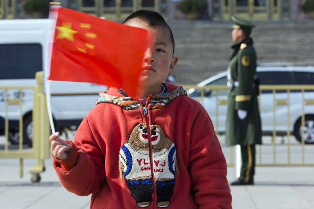 A child poses for photos with a Chinese national flag near the Great Hall of the People in Beijing. Goldman partner Roy Smith sees problems for China such as the burden of an ageing population, with mounting pension and health-care costs. Photo: AP