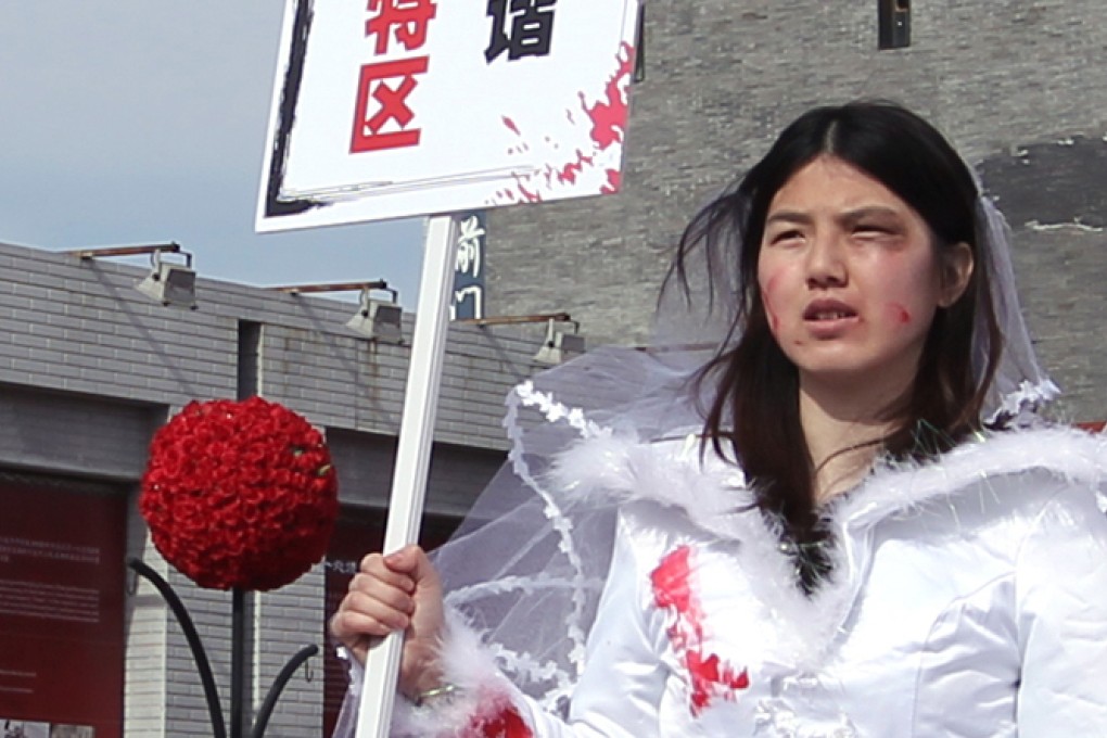 Li Tingting, who goes by the pseudonym Li Maizi, pictured in Beijing's Qianmen Street campaigning against domestic violence in 2012. She appeared with two other university students wearing bloodied wedding gowns. Photo: Simon Song