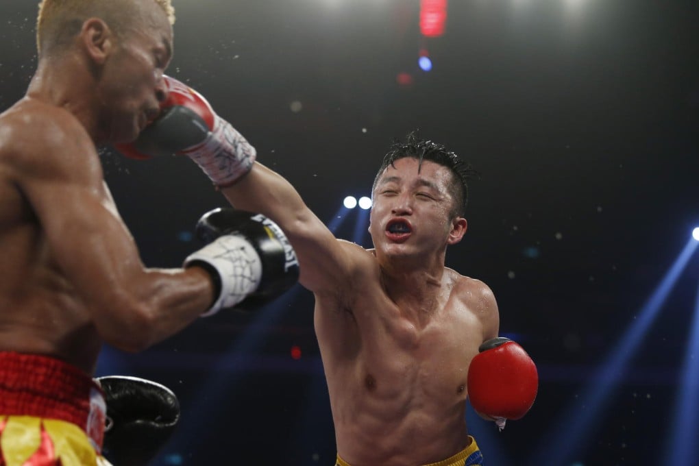 China's Zou Shiming hits out at Thailand's Amnat Ruenroeng during their IBF flyweight world title bout in Macau last night. Photo: AP