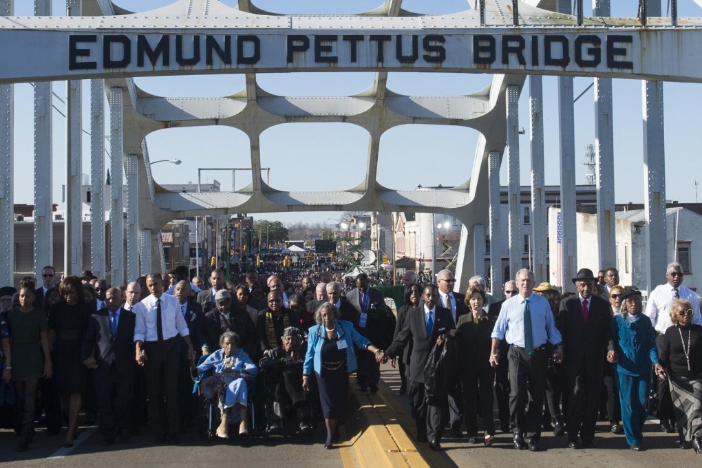 US President Barack Obama (sixth left) and US Congressman John Lewis (fifth left), one of the marchers 50 years ago, lead a walk across the Edmund Pettus Bridge. Photo: AFP
