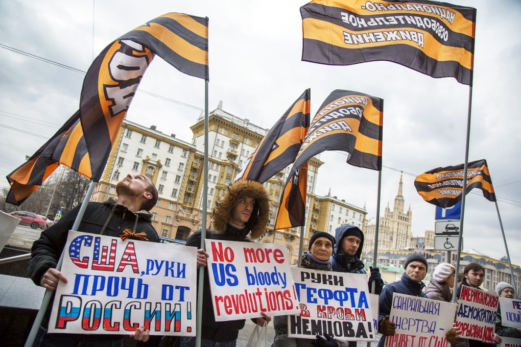 People hold anti-American posters reading 'Hands off Russia!, No more Bloody revolutions!, Blood of Boris Nemtsov is on U.S. Ambassador to Russia John Tefft's hands' gather in front of U.S. Embassy to protest against American  foreign policy in Moscow, Russia on March 7, 2015. Photo: AP