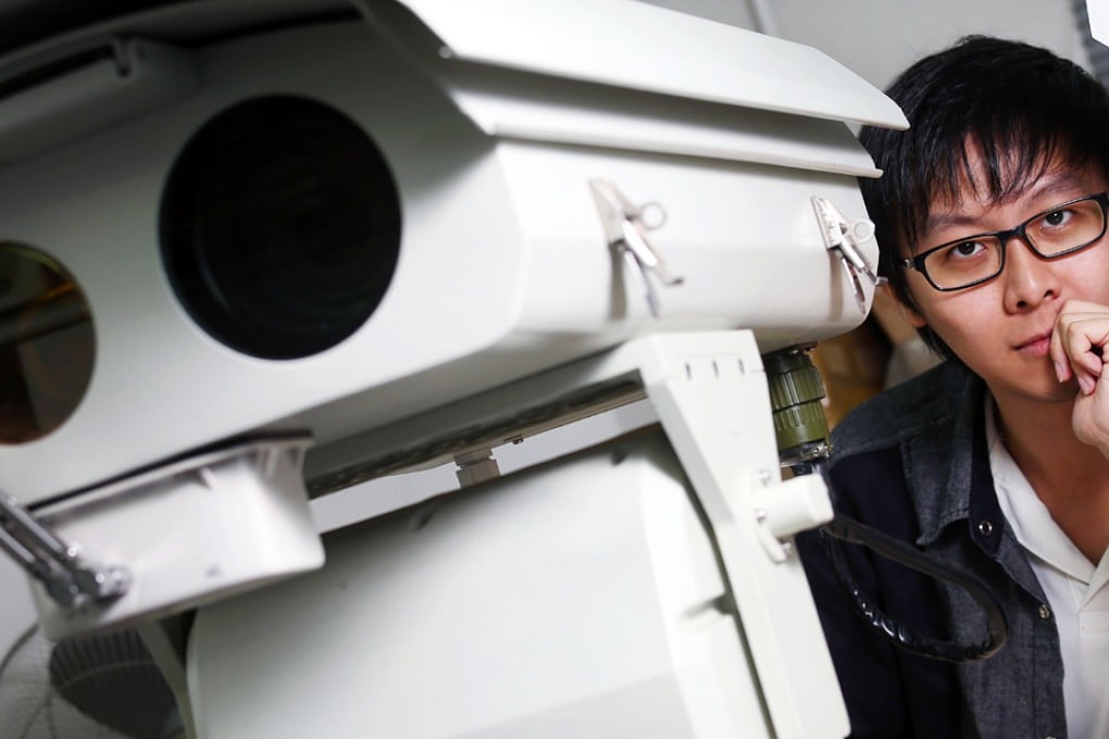 Rex Sham Pui-sum of Insight Robotics poses next to a robot equipped with a wildfire detection system. Photo: K.Y. Cheng