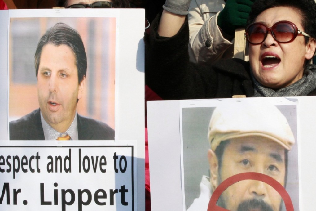 South Korean conservative activists with a portrait of US Ambassador to South Korea Mark Lippert (left) and Kim Ki-jong, the suspect of slashing Lippert, stage a rally near the US embassy in Seoul. Photo: AP