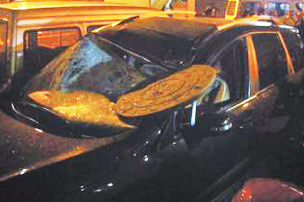 The car pictured after it was struck by the man-hole cover. Photo: SCMP Pictures