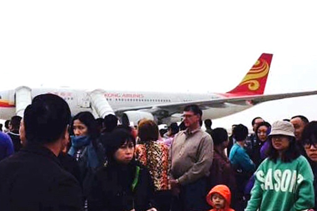 Passengers wait on the tarmac after being evacuated. Photo: SCMP Pictures