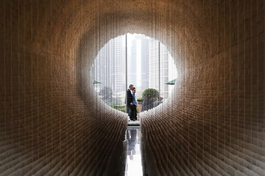 Two people walk past Zhu Jinshi's Boat at Exchange Square in Central. It is one of several installations in place for Art Basel, which will also feature exhibitions and panel discussions. Photo: Sam Tsang