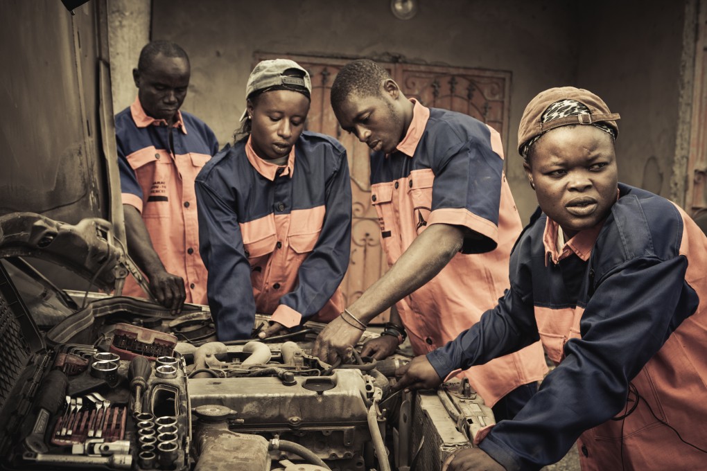 Female car mechanics Fatou Sylla and Fatou Camara at their garage in Dakar, Senegal. Photo: Anthony Kutrz