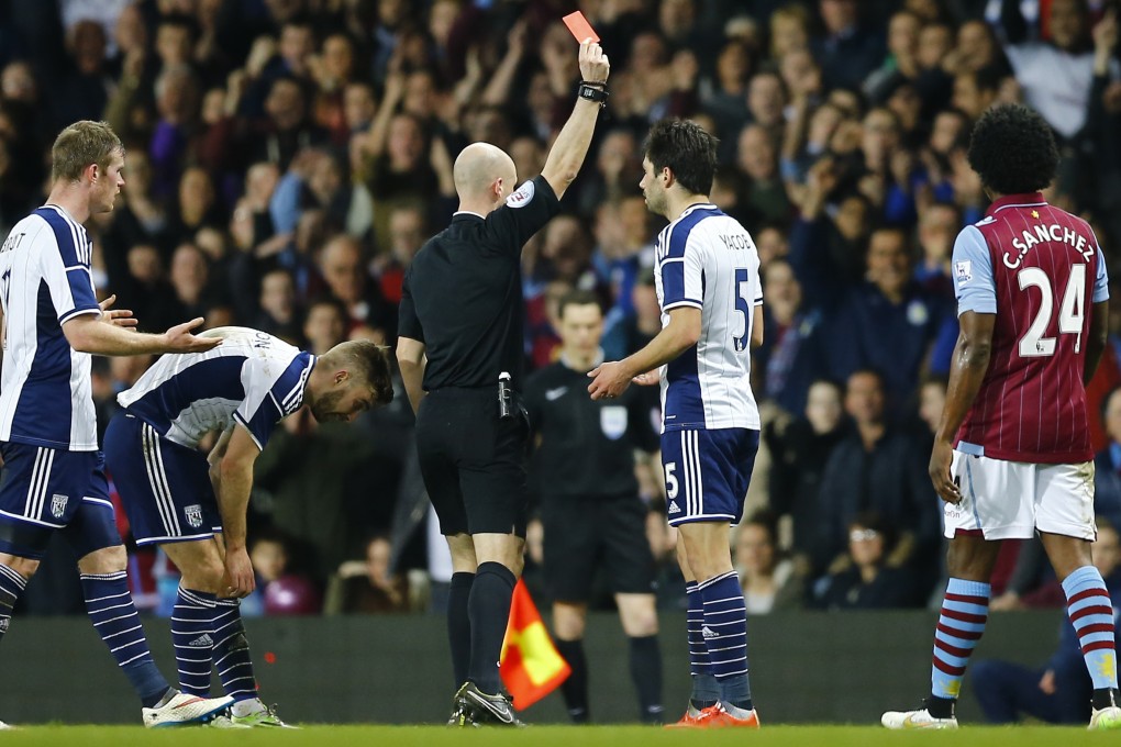 Referee Anthony Taylor sends off West Brom's Claudio Jacob. Colour psycghology suggests black shirts command discipline. Photo: Reuters