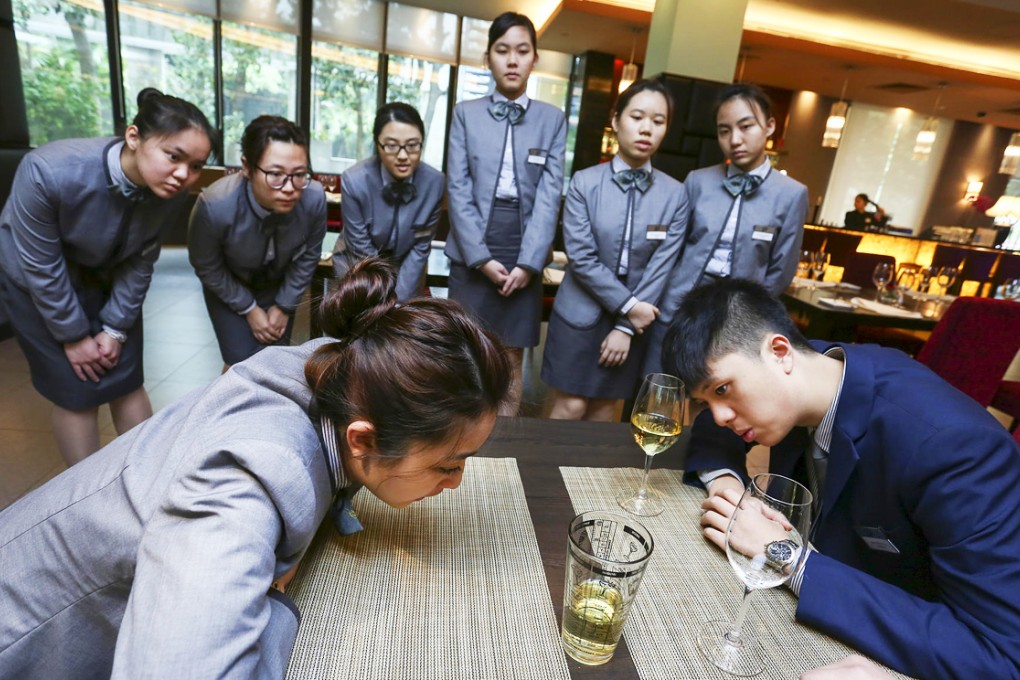 Macau Institute for Tourism Studies students gauge the amount of wine in a standard pour.