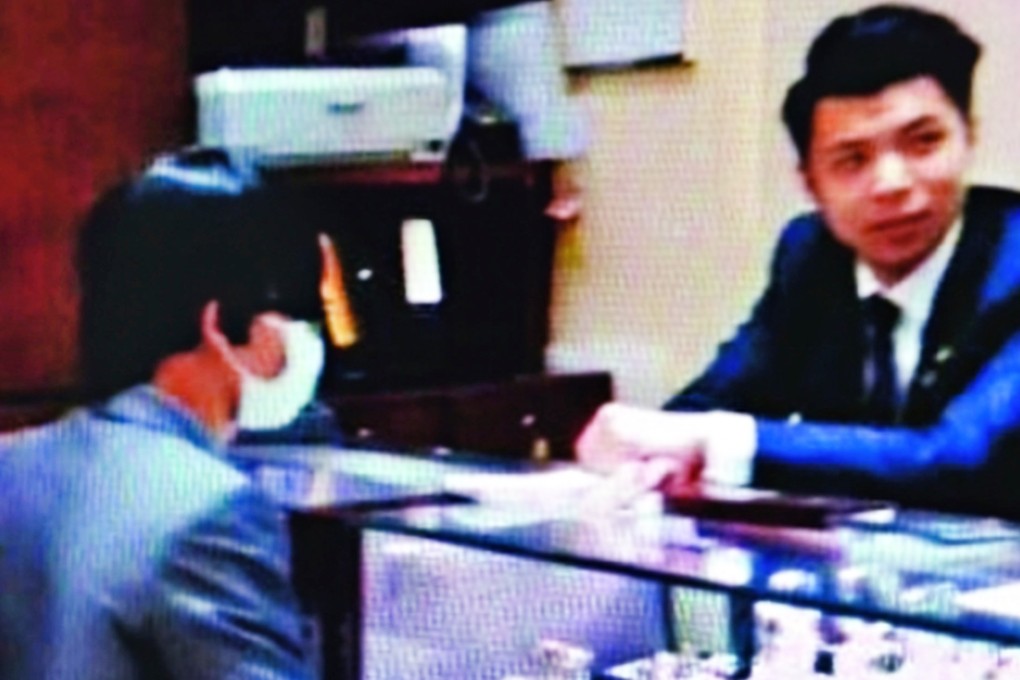 A suspected gunman, wearing a surgical mask and a wig, posed as a customer when he talked to staff in the watch shop in Peking Road, Tsim Sha Tsui. Photo: SCMP Pictures