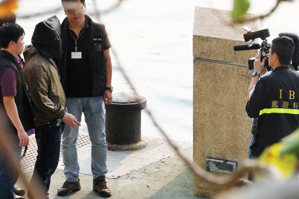 Tse Chun-kei, friend of Henry Chau, is escorted by police officers to a water front near The Long Beach in Tai Kok Tsui on March 16, 2013. Photo: Felix Wong