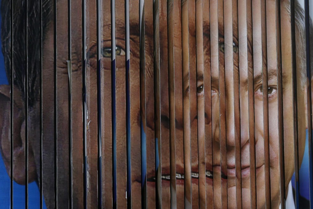 A rotating billboard in Tel Aviv shows prime-minister candidates Benjamin Netanyahu (right) and opposition chief Isaac Herzog. Photo: EPA