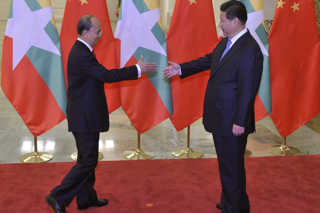 Myanmar President Thein Sein (left) extends a hand to Chinese President Xi Jinping before a meeting in Beijing. Photo: EPA