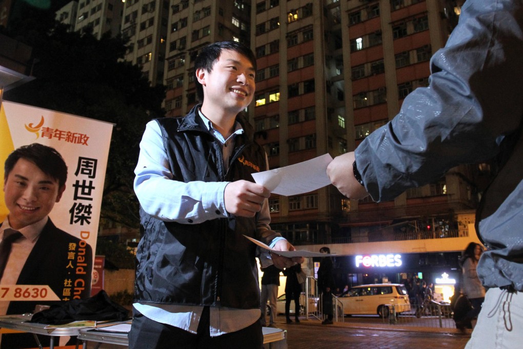 Youngspiration spokesman Donald Chow Sai-kit hands out questionnaires to residents in Kennedy Town, where he intends to stand in the district council elections. Photo: May Tse