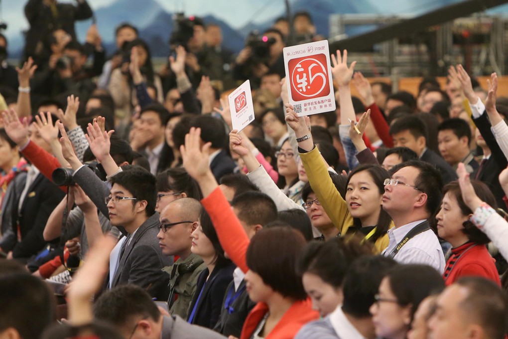 Journalists hoping to get picked to ask their questions. Photo: Xinhua