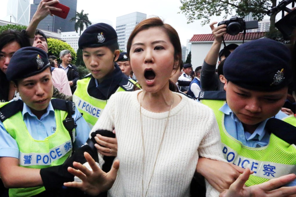 People Power chairwoman Erica Yuen Mi-ming protests as she is led away by police from Government House during yesterday's open day. Photo: Felix Wong