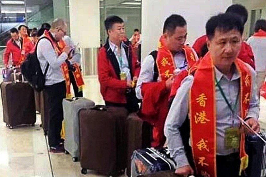 A business delegation from the mainland wear sashes declaring they are not in Hong Kong to shop as they head through Chek Lap Kok airport, according to a post on the Weibo microblog portal. Photo: SCMP Pictures
