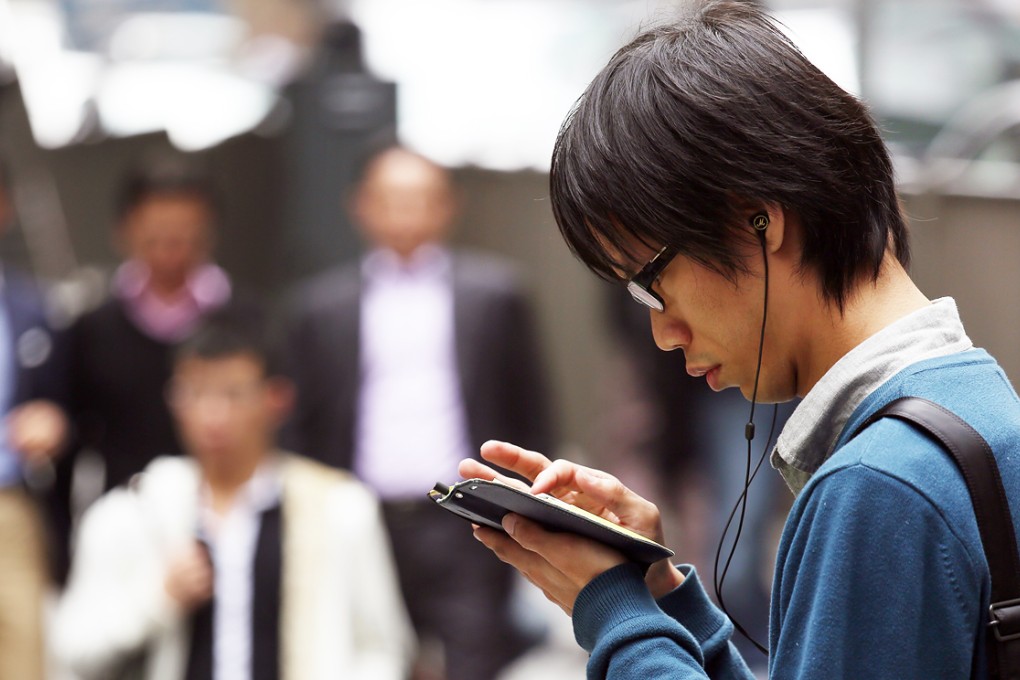 A man uses his smartphone on the street in Hong Kong. Network operators in the city are making it easier for subscribers to switch phones. Photo: Nora Tam