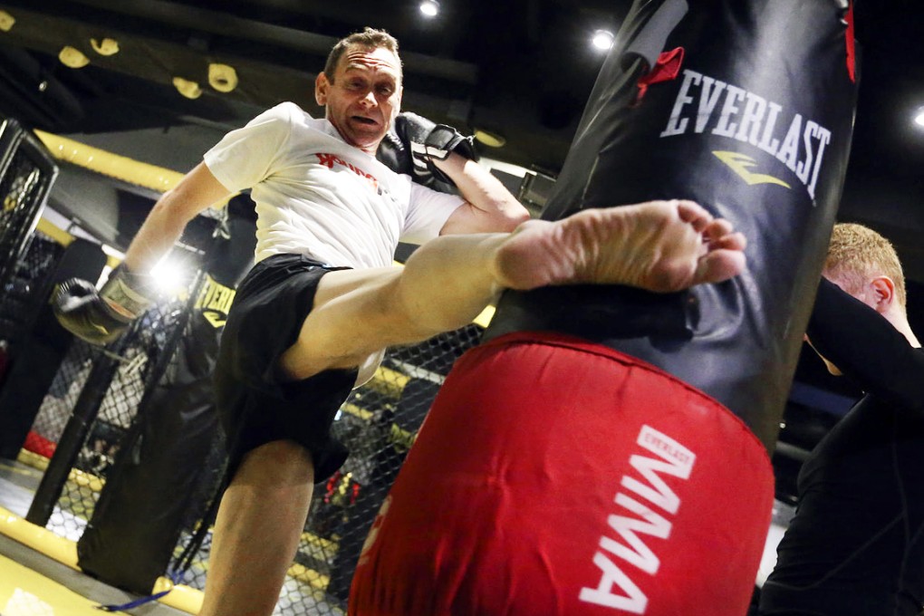 Reporter Mark Sharp gives the heavy bag a mean roundhouse kick. Photo: K.Y. Cheng