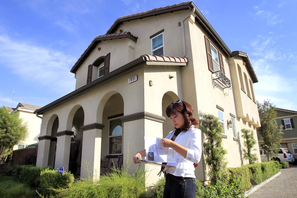 An agent who specializes in buying houses for Chinese investors, checks her listings while touring homes for sale in California.
