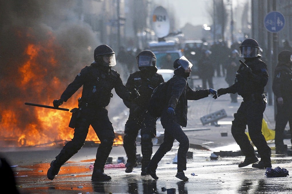 German riot police officers clash with a protestor outside the new ECB headquarters during riots in Frankfurt. Photo: Reuters