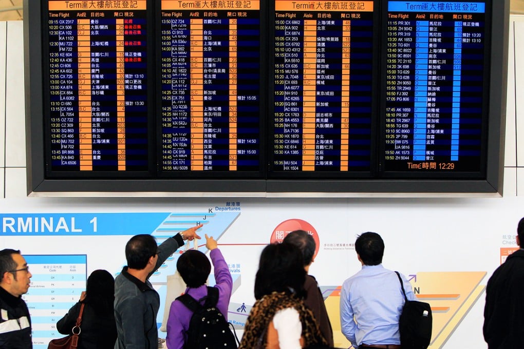 Passengers check flight schedules at Hong Kong International Airport. Photo: Jonathan Wong