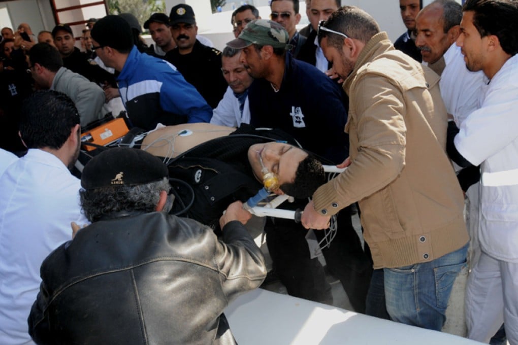 Paramedics and doctors help a wounded man onto an ambulance after the shooting attack at Tunis's National Bardo Museum. Photo: Xinhua