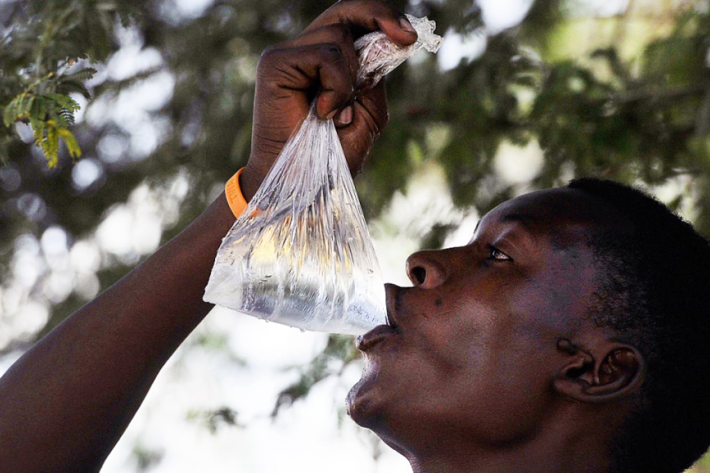 A water vendor drinks water from a polythene bag in Athi river town some 27km from Nairobi. Photo: AFP