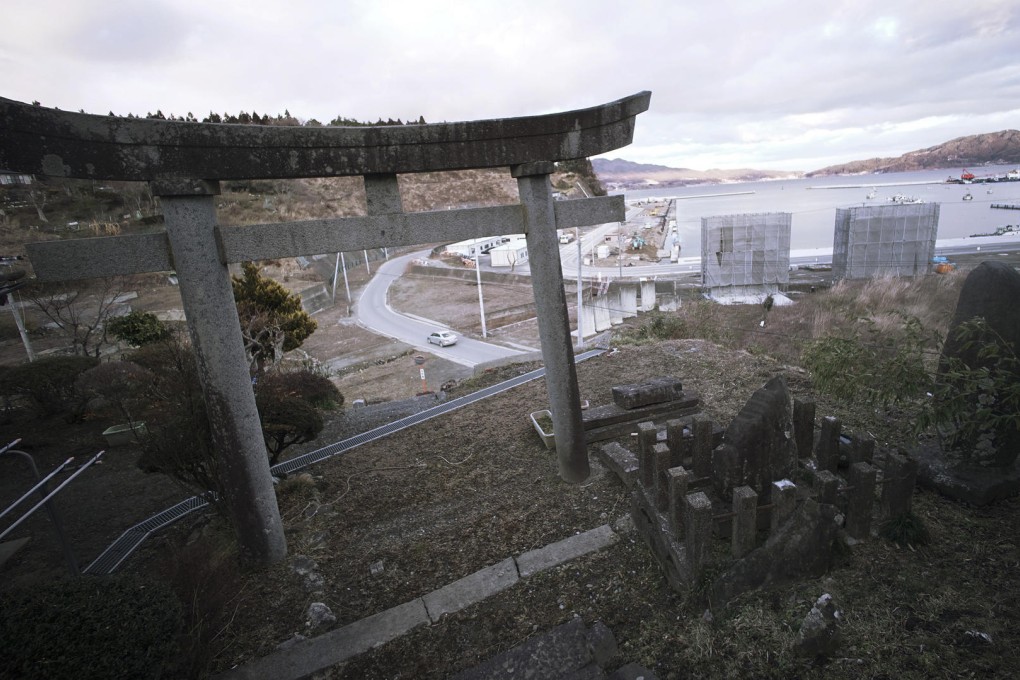 A Shinto shrine gate overlooks a construction site where sea walls are being built along the waterfront area in Rikuzentakata, four years after a tsunami devastated much of Japan's northeastern coast. Photo: AP