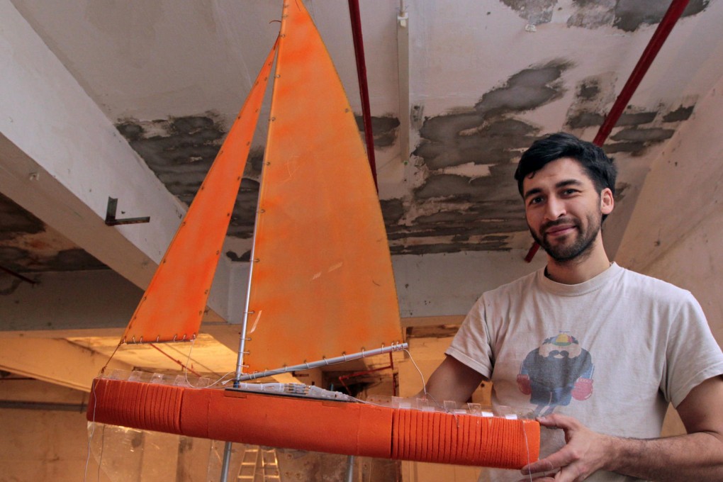 Inventor Cesar Harada, chief executive of Scoutbots, with a model of one of his robotic sailing boats at the Yau Tong factory building he calls "Make Bay". Photo: Bruce Yan