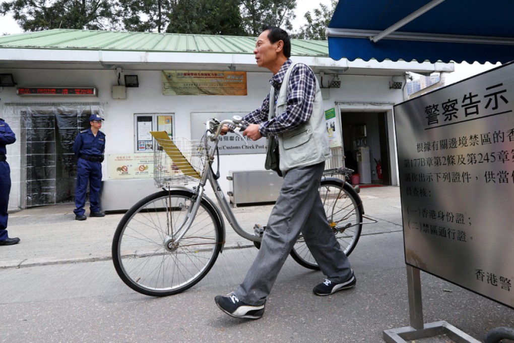 Police stand guard at the Chung Ying Street post in the partially closed-off border town of Sha Tau Kok yesterday. District councillors want the government to open a shopping mall in the area for mainland visitors. Photo: Nora Tam