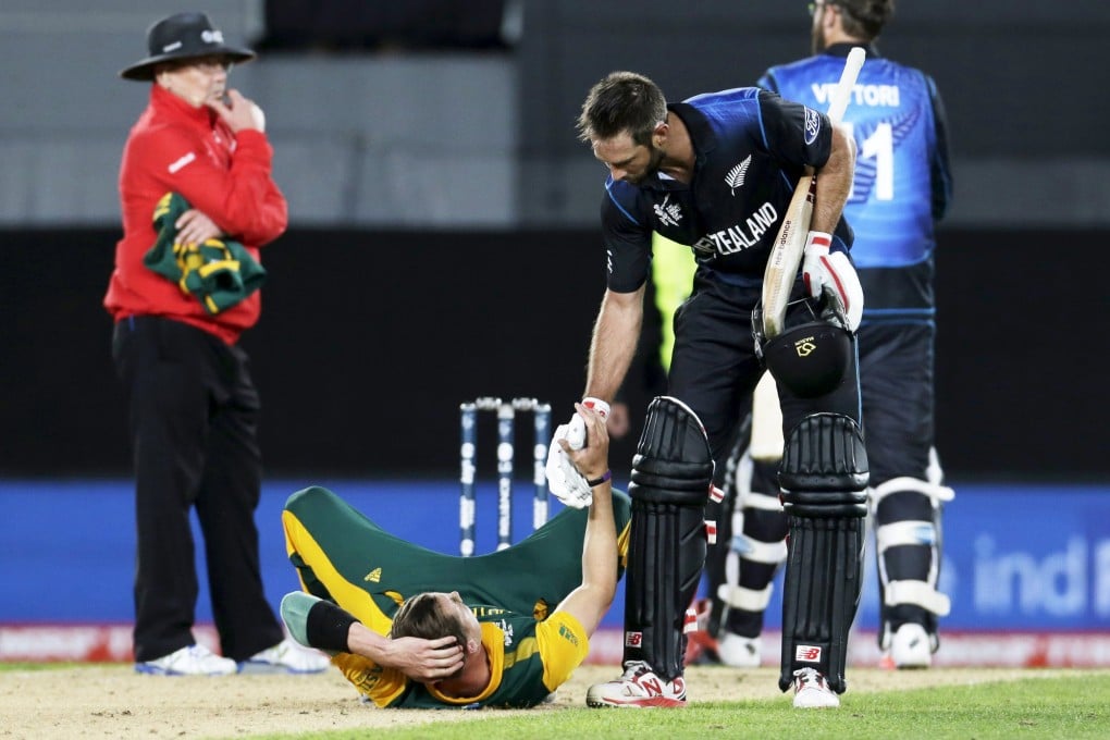 New Zealand batsman Grant Elliott helps up a distraught Dale Steyn after hitting the winning six. Photo: Reuters