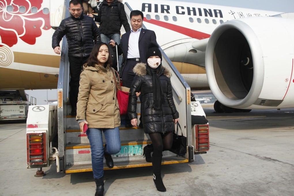 An 'economic fugitive' wearing a mask is pictured on her return to China last month after allegedly spending 10 years on the run in Italy. Photo: Xinhua