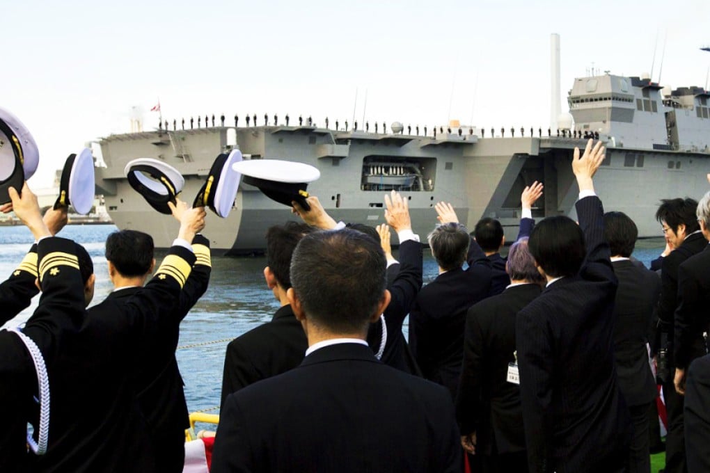 Navy servicemen wave as the Izumo leaves port. Photo: Reuters