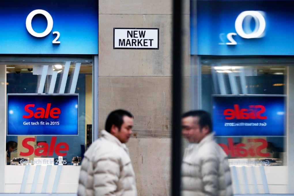 A Manchester pedestrian passes by an O2 mobile phone store, previously operated by Spain's Telefonica SA but recently acquired by Hutchison Whampoa. Photo: Bloomberg