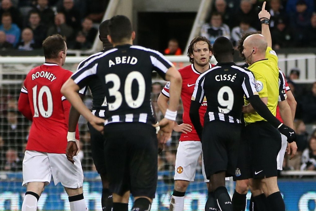 The referee reacts after a clash of Manchester United defender Jonny Evans with Newcastle striker Papiss Cisse. Photo: AFP