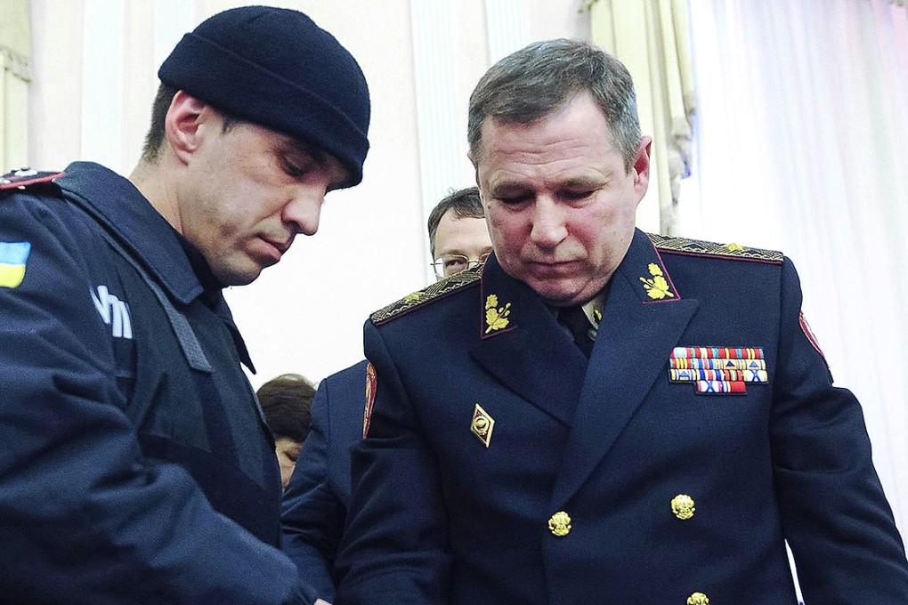 A policeman places handcuffs on Vasyl Stoyetsky. Photo: EPA