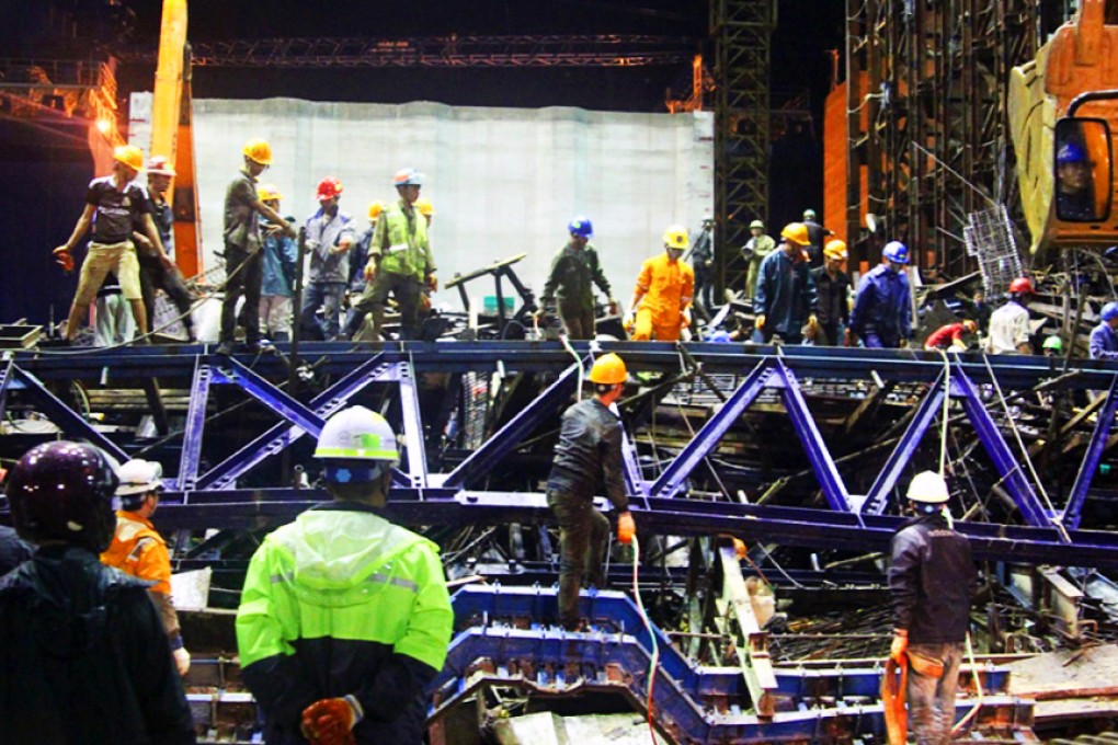 Rescue helpers clean up after a scaffolding collapsed in an economic zone in central Vietnam. Photo: EPA