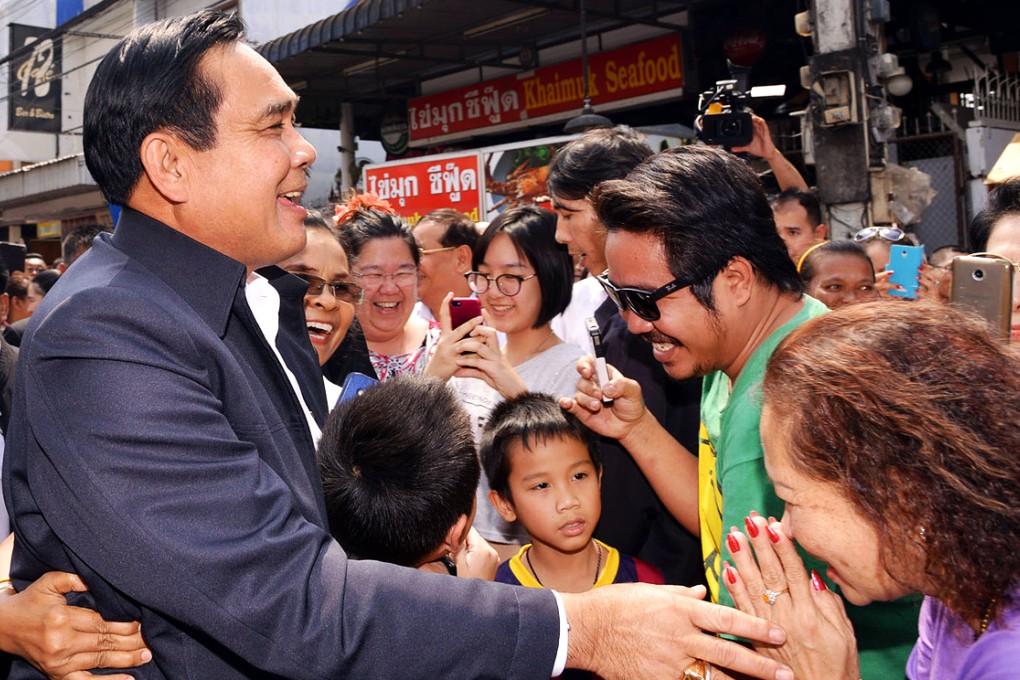 Thai Prime Minister Prayut Chan-ocha  greets people during his visit to Chatrachai market in Hua Hin. Photo: Xinhua