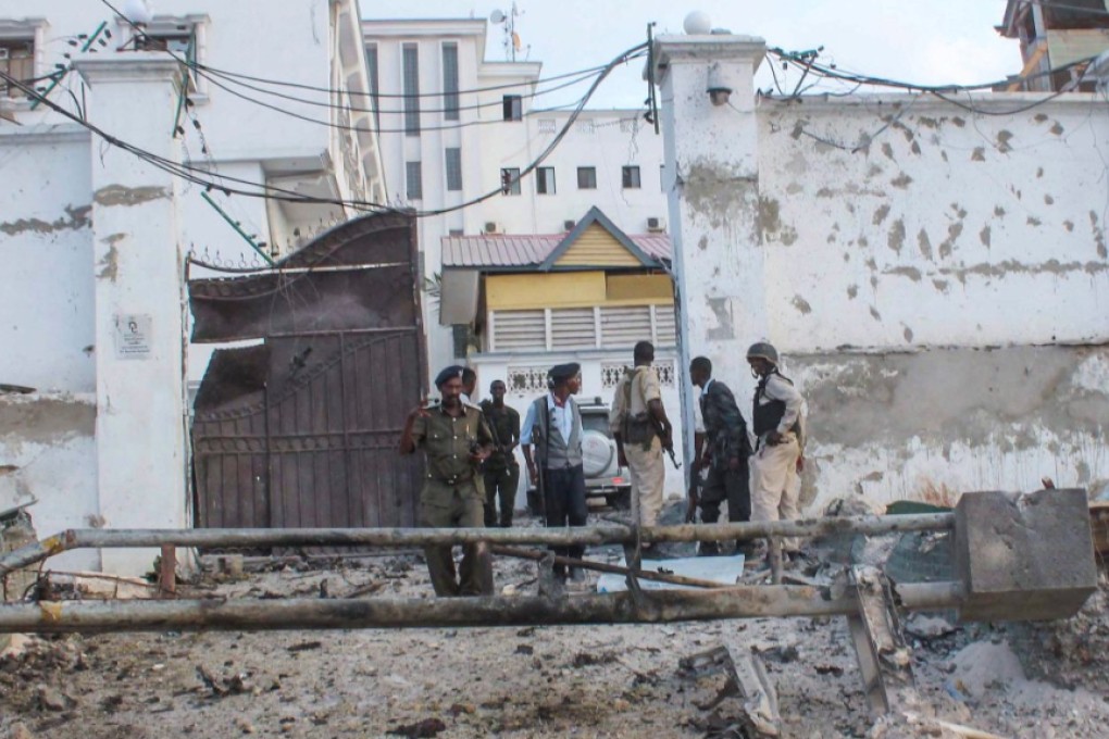 Somali security officers stand guard at the scene of a car bomb explosion in front of a hotel in Mogadishu. Photo: EPA