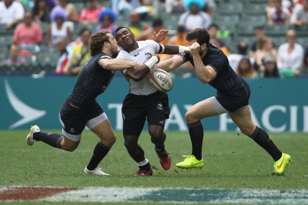 Fiji’s Jerry Tuwai runs into trouble in the Cup quarters against England. Photos: Nora Tam/SCMP