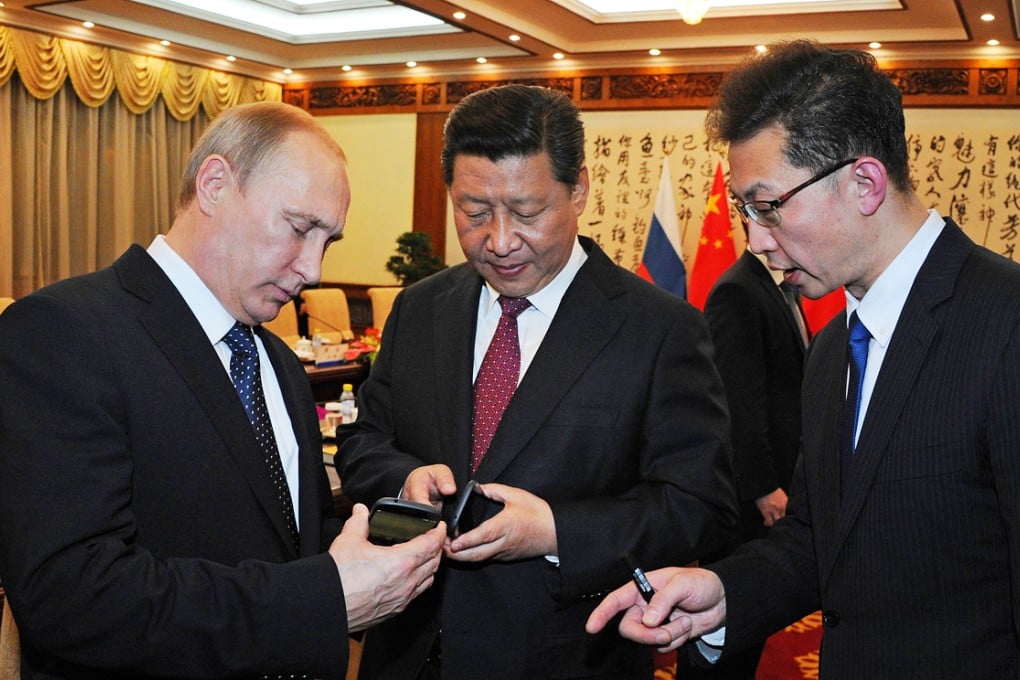 Russian president Vladimir Putin (left) gave his Chinese counterpart Xi Jinping (centre) a YotaPhone 2 at the APEC summit in November 2014. Photo: AFP