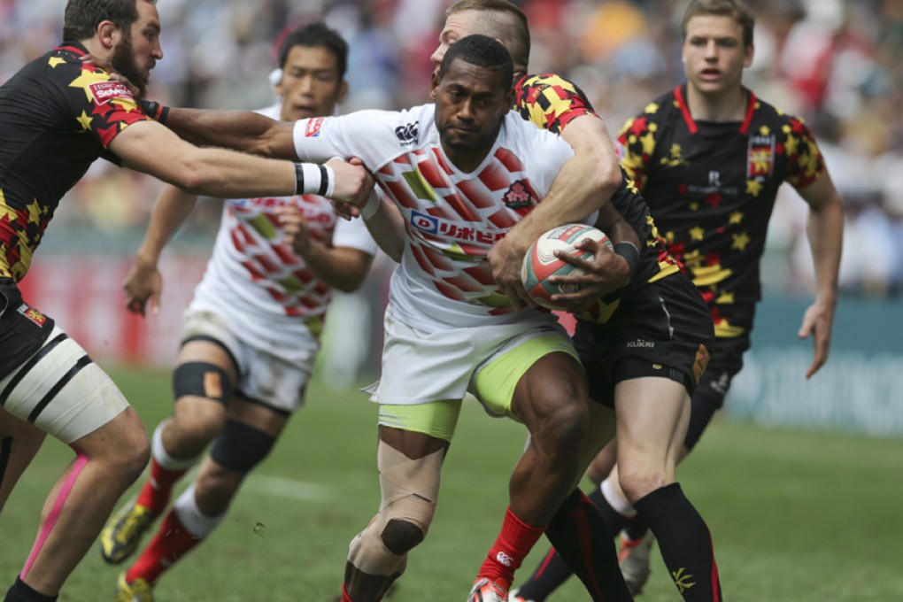 Japan's Lote Tuqiri is tackled by Belgium captain Mathieu Verschelden (left) as he advances during their Shield semi-final on Sunday. Photos: Sam Tsang/SCMP